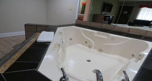 a large white bath tub in a bathroom at SureStay Plus Hotel by Best Western St Marys Cumberland in Saint Marys