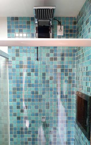 a blue tiled bathroom with a blue tile wall at Chalé Kerstin Ar condicionado Pousada 35knots Brasil in Luis Correia