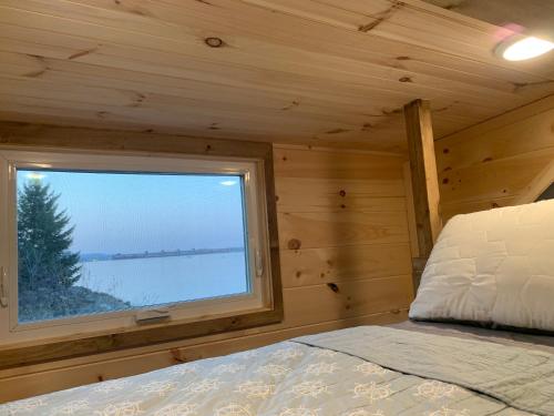 a bedroom with a window in a log cabin at Riverbottom - Tiny Home 2 in Bellevue