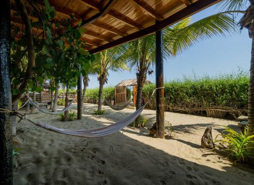 a hammock on a beach with palm trees at Las Olas in Máncora