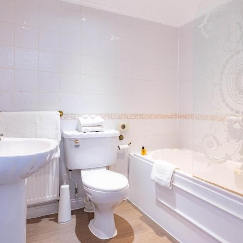 a bathroom with a toilet and a sink and a tub at The Derwentwater Hotel in Keswick
