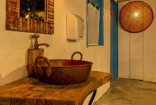un lavandino in rame su un bancone in legno in una stanza di Pousada Astral Mucugê a Arraial d'Ajuda