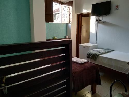 a small room with a bed and a window at Pousada Iguape in Iguape