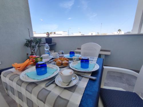 einen Tisch mit Tellern aus Essen auf einem Balkon in der Unterkunft B&B DreAm Porto Cesareo in Porto Cesareo