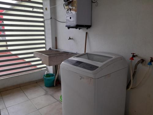 a washing machine in a room with a sink at Departamento completo familias o grupos in Toluca