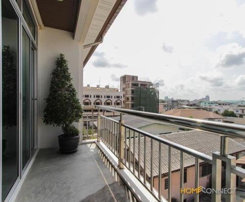 een balkon met een potboom en uitzicht op de stad bij T Series Place Serviced Apartment in Bangkok