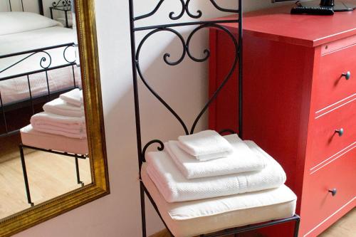 - une pile de serviettes sur un portant à côté d'un miroir dans l'établissement Bernardone, à Camaiore