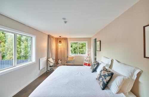 a bedroom with a large bed and two windows at HUs - Boutique Venue & Accommodation in Riverhead