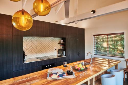 a kitchen with a wooden counter and a sink at HUs - Boutique Venue & Accommodation in Riverhead
