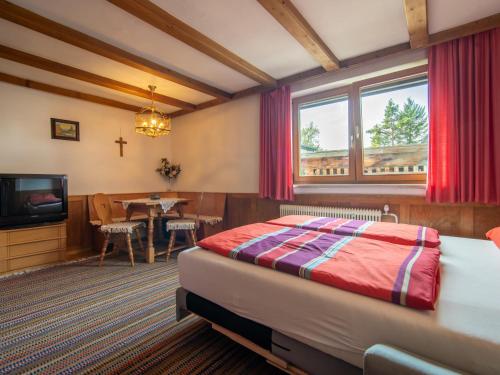 a bedroom with a bed and a tv and a table at Haus Wammes in Silz