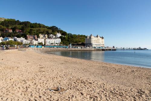 a beach with a large body of water at The Marine Hotel in Llandudno
