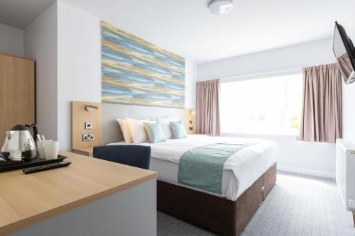 a hotel room with a bed and a desk at The Marine Hotel in Llandudno