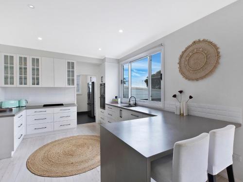
a kitchen with a dining table and a large window at Waterview Beach house in Shelly Beach
