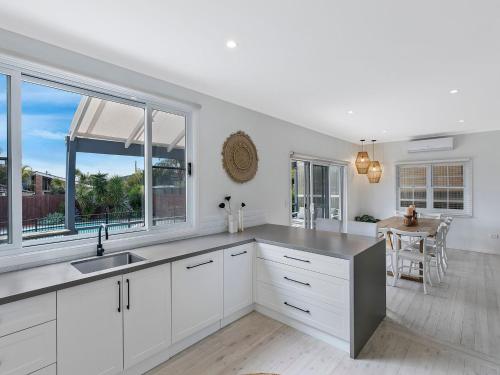 
a kitchen with a white counter top and white cabinets at Waterview Beach house in Shelly Beach
