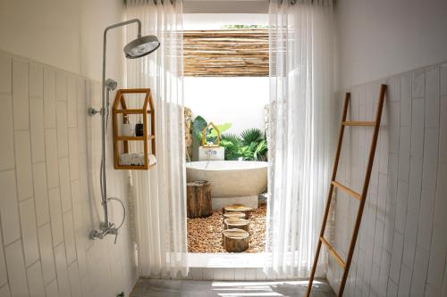 a bathroom with a bath tub and a window at Montagne Residence in Kampot