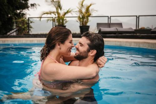 a man and woman hugging in a swimming pool at Empedrada Ranch & Lodge - Hotel Asociado Casa Andina in Caral