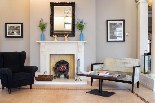 a living room with a fireplace and a table and a mirror at The Caledonian New Southlands Hotel in Scarborough