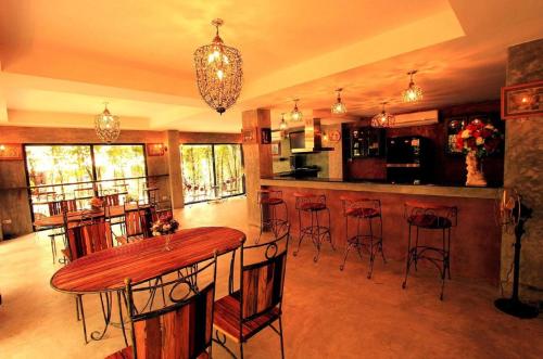cocina con mesa de madera y barra con taburetes en G2 Boutique Hotel, en Chiang Mai