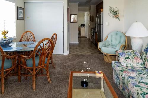 een woonkamer met een bank en een tafel en stoelen bij Sea Sands 101 in Ocean City