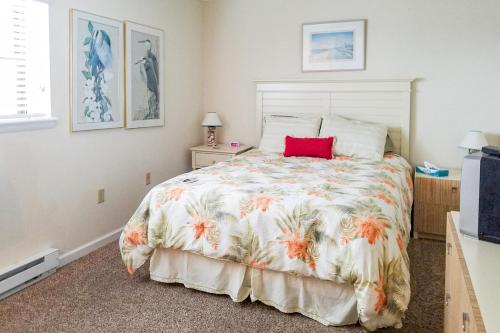 een slaapkamer met een groot bed met een rood kussen erop bij Sea Sands 101 in Ocean City