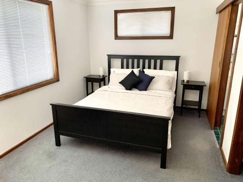 a bedroom with a large bed with two night stands at Gale Street Retreat Busselton in Busselton