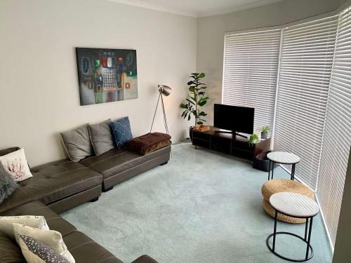 a living room with a couch and a tv at Busselton Beach House with WiFi in Busselton