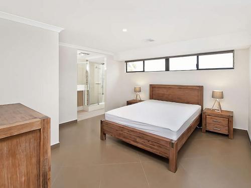 a bedroom with a bed and two tables and a window at Ocean Walk Abbey in Vasse