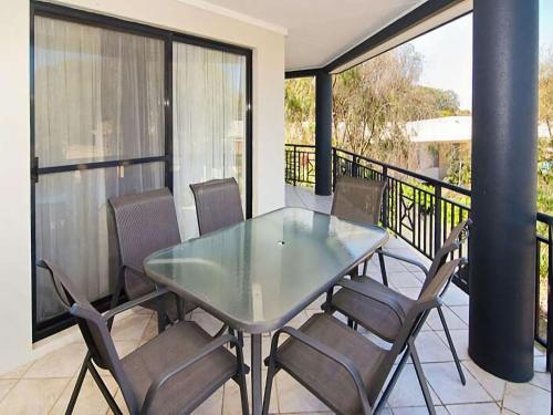 a glass table and chairs on a balcony at Sixteen at Cape View Escapes in Busselton