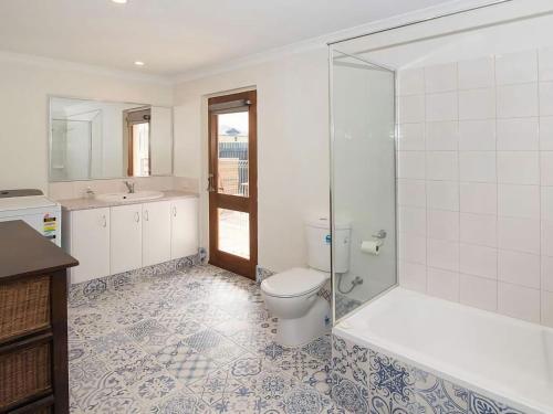 a bathroom with a toilet and a glass shower at Studio 66 Busselton in Busselton