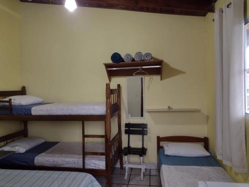 Habitación con 3 literas y espejo. en Hospedaria Casa do Sol - divisa Caraguá e São Sebá, en Caraguatatuba