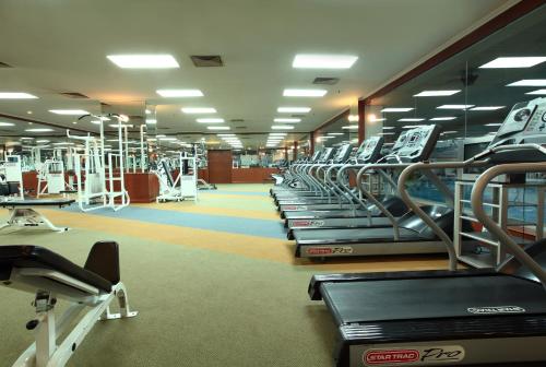 a gym with a row of treadms and machines at Beijing New Century Hotel in Beijing