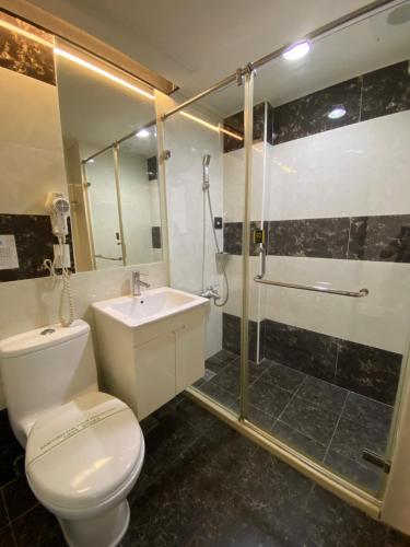 y baño con aseo, ducha y lavamanos. en Dreamer Hotel en Budai