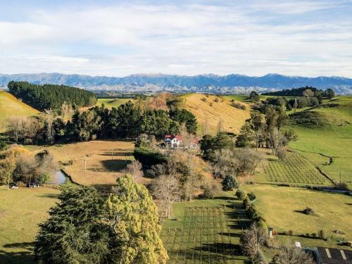 an aerial view of a field with a house on a hill at Ashcott Homestead Bed & Breakfast in Takapau