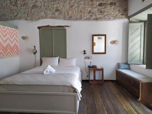 a bedroom with a bed and a bench in a room at Latmos 1860 in Skala