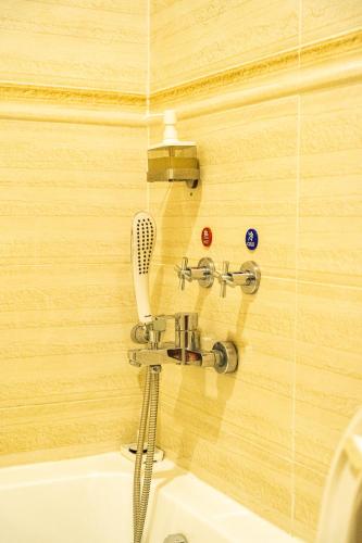 a bathroom with a shower head and a sink at Suwara Hotel Kepong KL in Kuala Lumpur