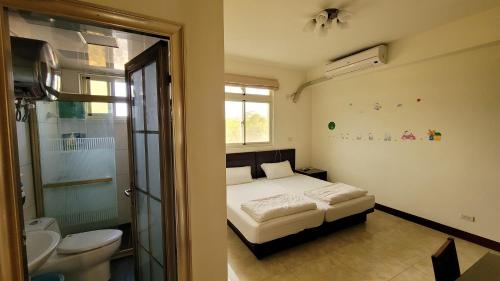 a bedroom with a bed and a bathroom with a toilet at 好宿民宿 in Jinning