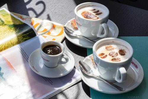 Dos tazas de café en platillos sobre una mesa. en The Royal Hotel Weymouth, en Weymouth