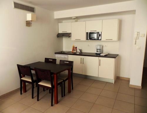 a kitchen with a table and chairs and a microwave at Residence Services Calypso Calanques Plage in Marseille