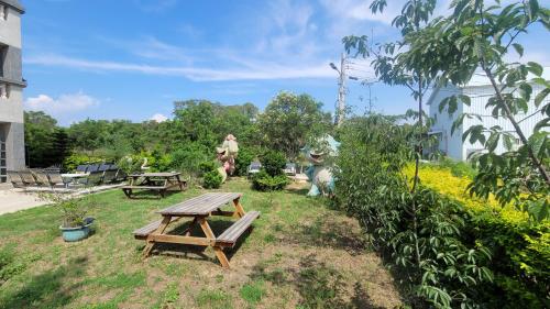 a wooden picnic table in a garden with a picnic table at 好宿民宿 in Jinning