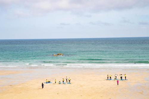 a group of people standing on the beach at The St Ives Bay Hotel in St Ives