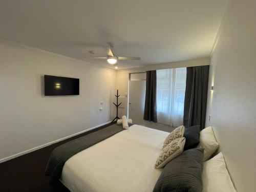 a bedroom with a bed and a tv on the wall at Royal Hotel Motel Scone in Scone