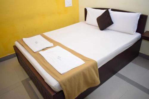 a bed with two white towels on top of it at Arudhra Residency in Chidambaram