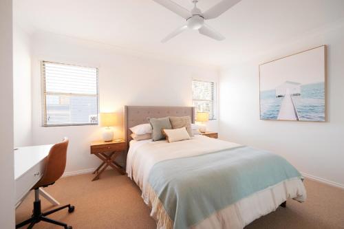 a white bedroom with a bed and a desk and a window at Harbour view huge 2 bedroom entire residence. in Sydney