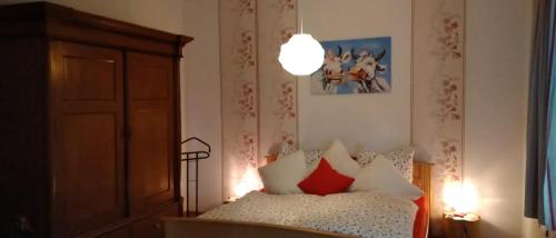 a bedroom with a bed with red and white pillows at Deichhof in Westoverledingen