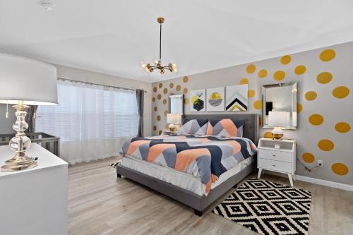 1 dormitorio con 1 cama con lunares de color naranja y amarillo en 6BR/4B Windsor Hills Villa, Pool & Game Room, 2 Miles from Walt Disney World, en Orlando