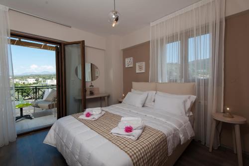 1 dormitorio con 1 cama con toallas y balcón en Villa Harmony-Crete Residences, en Adelianos Kampos