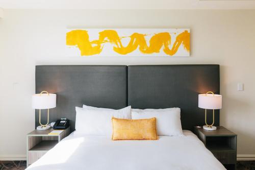 a bedroom with a large white bed with two lamps at voco Gold Coast by IHG in Gold Coast