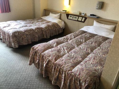 a hotel room with two beds in a room at パーク琴芝 in Ube