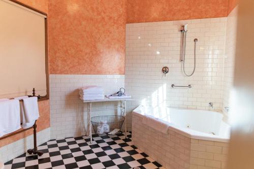 North Adelaide Heritage Cottages & Apartments في أديلايد: حمام مع حوض استحمام ودش