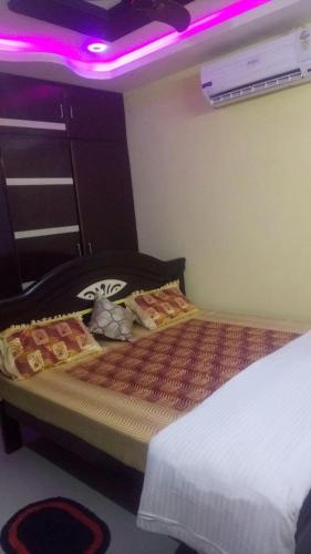 a bedroom with a bed with a purple light at gratifiedhomestay in Visakhapatnam